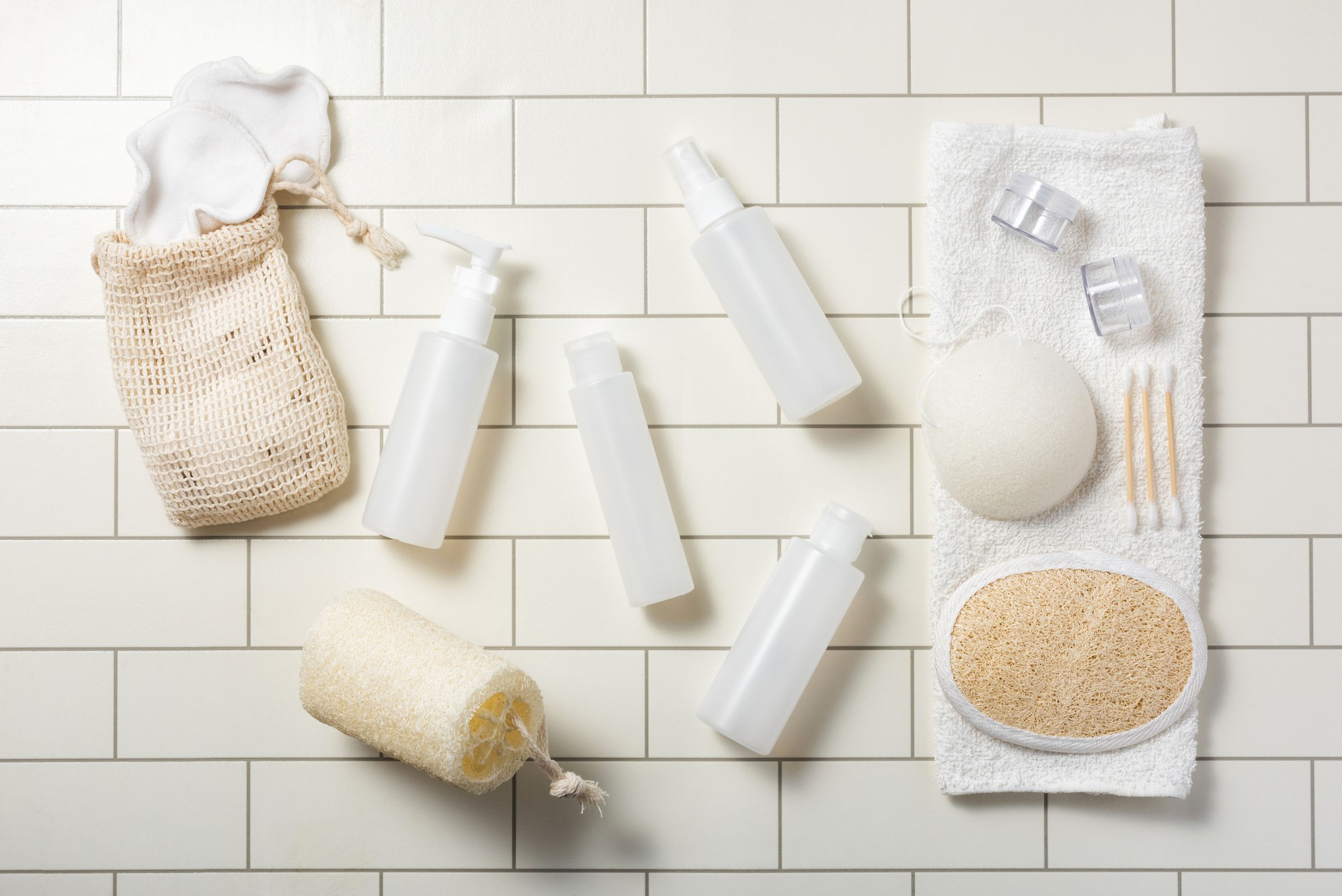 Compact toiletry cosmetic products on white bathroom tiles